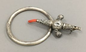 A Victorian unmarked silver child's rattle and a bangle