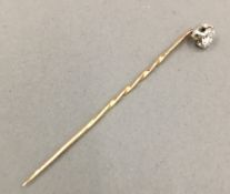A diamond set unmarked gold stick pin