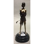 A bronze figure of a female dominatrix