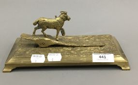 A brass desk clip mounted with a sheep