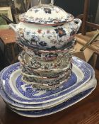 Four 19th century blue and white willow pattern meat plates together with 19th century tureens,