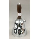 A vintage bell shaped chrome cocktail shaker with wooden handle