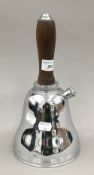 A vintage bell shaped chrome cocktail shaker with wooden handle