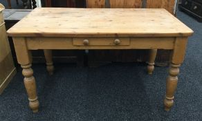 A modern pine kitchen table with a single drawer