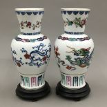 A pair of Franklin Mint Chinese porcelain vases on wooden stands
