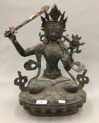 A large Eastern bronze deity holding a with sword