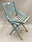 A vintage blue painted child's folding chair