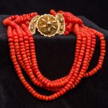 A five strand coral bead necklace Set with an 18 ct gold filigree clasp. Approximately 46 cm long.