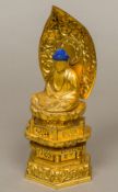 A Buddhist carved giltwood and lacquered shrine Set with a seated model of Buddha before a carved