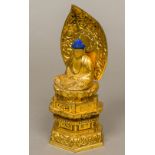 A Buddhist carved giltwood and lacquered shrine Set with a seated model of Buddha before a carved