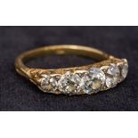 An 18 ct gold and diamond five stone ring Set with scroll pierced shoulders,