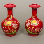 A pair of Chinese red ground porcelain vases Each decorated in relief with birds amongst floral