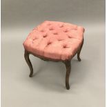 A carved beech stool The serpentine seat button upholstered, standing on slender cabriole legs.