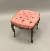 A carved beech stool The serpentine seat button upholstered, standing on slender cabriole legs.