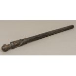 An African tribal carved wooden staff The finial formed as seated bearded figure,