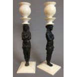 A pair of ivory mounted figural bronze cast candlesticks The turned socles supported on classical
