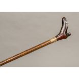 A Victorian walking stick The handle formed as a pique inlaid boot above the gold plated collar and