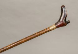 A Victorian walking stick The handle formed as a pique inlaid boot above the gold plated collar and