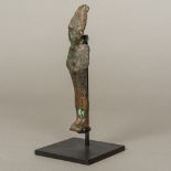 An ancient Egyptian antiquity iron shabti Of typical form, mounted on a later display stand.