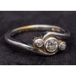 An 18 ct white gold three stone diamond crossover ring The central stone approximately 0.25 carat.