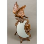 A late 19th/early 20th century Black Forest mirror Carved with a bird of prey above the crescent