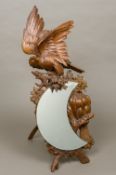 A late 19th/early 20th century Black Forest mirror Carved with a bird of prey above the crescent