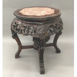 A Chinese carved rosewood marble inset urn stand The shaped top above a profusely carved apron and