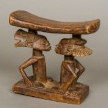 An African tribal wooden headrest The stand carved as two kneeling figures. 17.5 cm high.