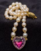 A pearl necklace Set with a 9 ct gold clasp and a diamond and paste set heart shaped pendant.