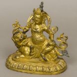 A Chinese gilt bronze figure of a deity Modelled seated atop a dog-of-fo. 18 cm high.
