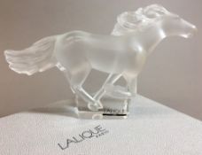 A Lalique frosted and clear glass Kazak horse Typically modelled, signed, boxed. 18 cm long.