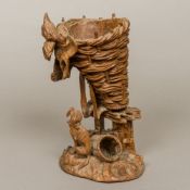 A 19th century Black Forest carved wooden vase Formed as a farm workers basket and jacket,