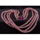 A French silver mounted amethyst glass bead necklace Of four strand form,