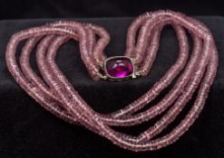 A French silver mounted amethyst glass bead necklace Of four strand form,