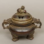 A Chinese patinated bronze censer The pierced lid with elephant finial,