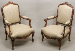 A pair of 19th century French upholstered rosewood open armchairs Each with scroll and floral
