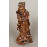 A Chinese carved wooden figure of an immortal Modelled in flowing robes holding a carved ruyi