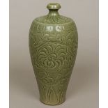 A Chinese celadon glazed pottery vase Decorated in the round with scrolling foliage. 30 cm high.