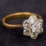 An 18 ct gold diamond flowerhead set ring 1.2 cm high.