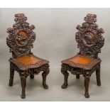 A pair of Victorian profusely carved oak hall chairs Each scroll carved top rail above a carved