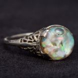 An 18K white gold ring With pierced shoulders and unusual cabochon stone enclosing an air bubble.
