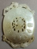 A Chinese carved celadon and russet jade roundel,