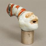 A Victorian porcelain walking stick handle Formed as a monkey wearing a hat;