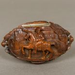 A 19th century coquilla nut snuff box The hinged oval lid carved with Napoleon on horseback before