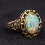 An unmarked bi-colour gold opal ring The central cabochon stone above the pierced border and