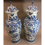 A large pair of 19th century Chinese blue and white porcelain vases and covers Decorated with