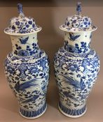 A large pair of 19th century Chinese blue and white porcelain vases and covers Decorated with