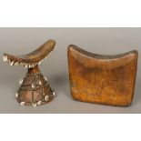 An African tribal carved wooden headrest Of typical curved form, with carved spreading central foot,
