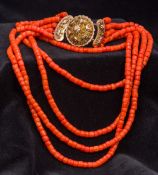 A five strand coral bead necklace Set with an 18 ct gold filigree clasp. Approximately 42 cm long.