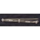 An Art Deco platinum and diamond set bar brooch Of pierced lobed form. 6.5 cm long.